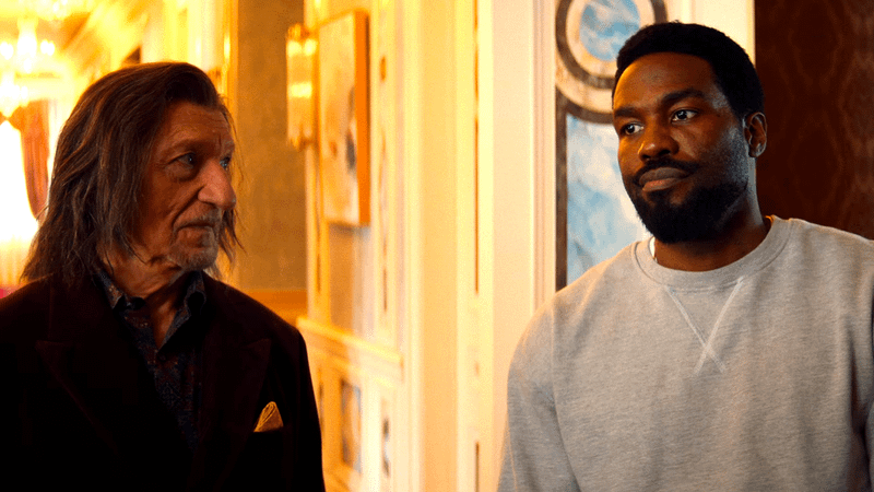 Ben Kingsley as Trevor Slattery next to Yahya Abdul-Mateen II as Simon Williams in a hallway in Wonder Man
