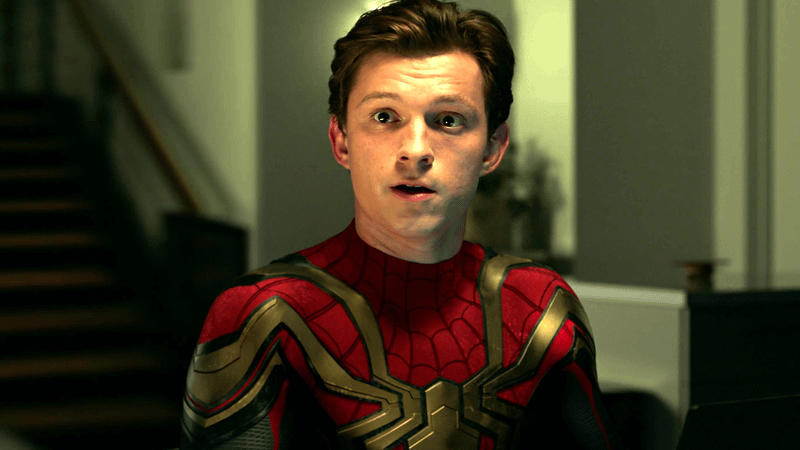 Tom Holland as Spider-Man without his mask standing in a living room in Spider-Man: No Way Home