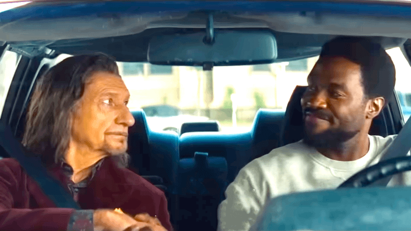Ben Kingsley as Trevor Slattery sitting next to Yahya Abdul-Matteen II as Simon Wiliams in a car in Wonder Man