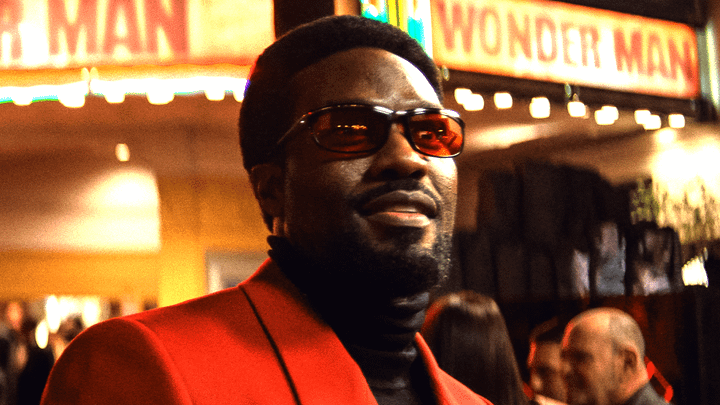 Yahya Abdul-Mateen II as Wonder Man wearing glasses and a red suit.